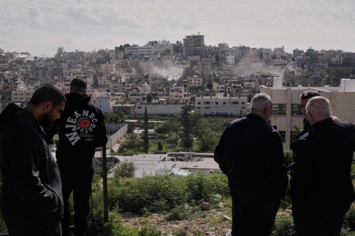 Palestinians watch as Israeli bulldozers claw down their West Bank homes